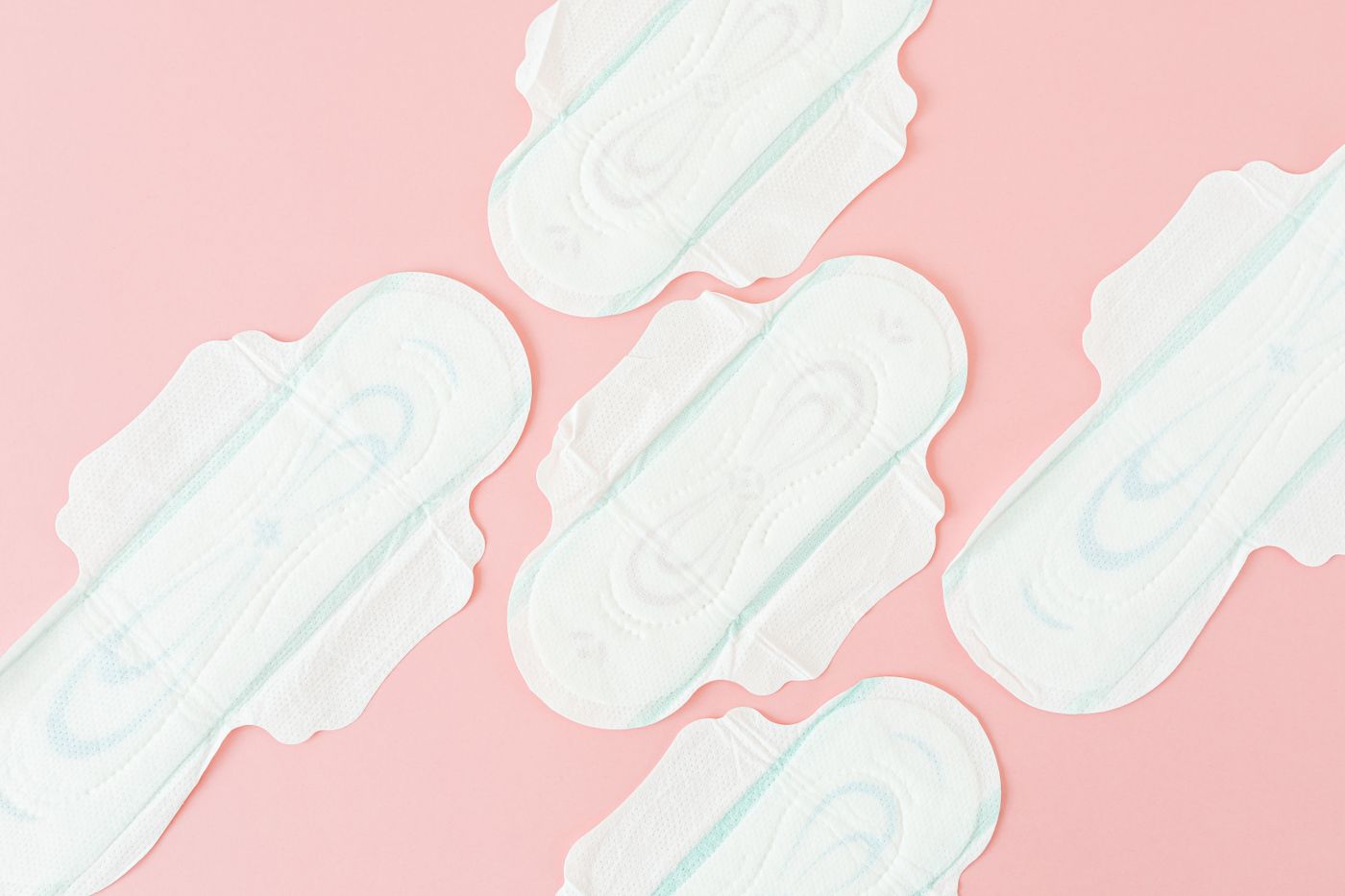 Sanitary pads arranged on a pink background for a guide to menstrual pain and endometriosis