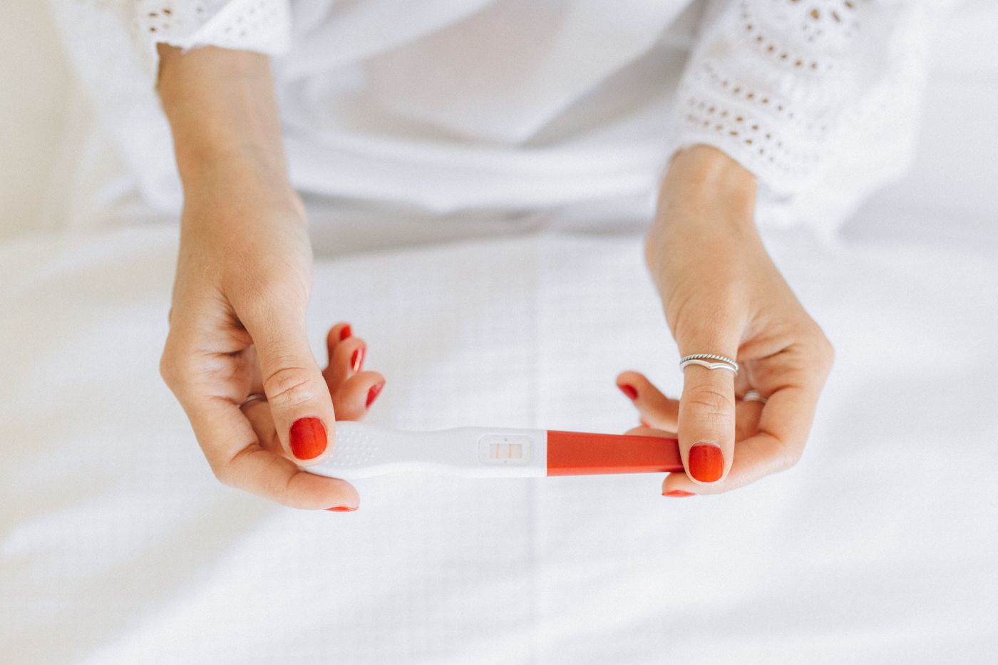 Hands holding a pregnancy test for an article about trying to conceive